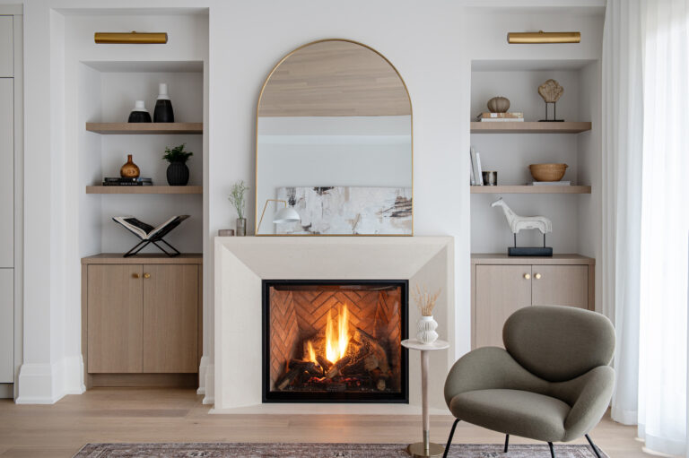 Veloce Homes interior: living room fireplace with arched brass mirror and oak built-ins
